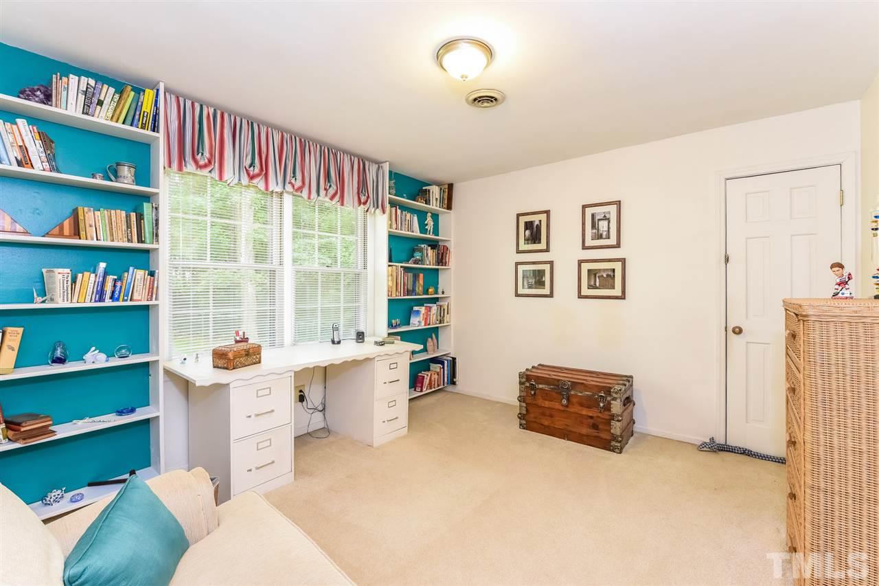 9716 Rock Creek Road Raleigh, NC 27613 - Photo 21 of 25 a living room with furniture and a bookshelf