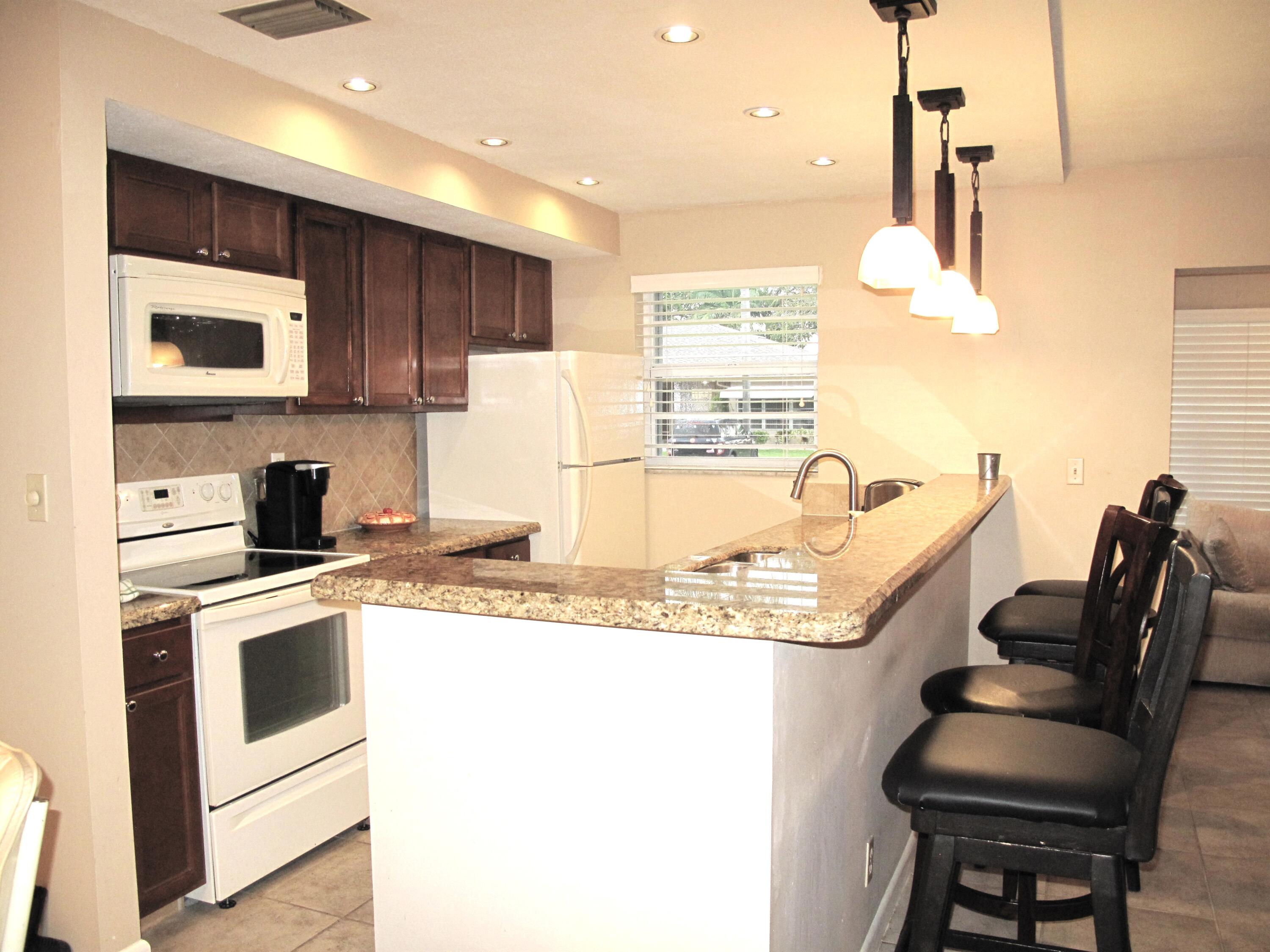 1315 High Point Way Southeast, Unit B Delray Beach, FL 33445 - Photo 1 of 41 a kitchen with a stove a sink and a refrigerator