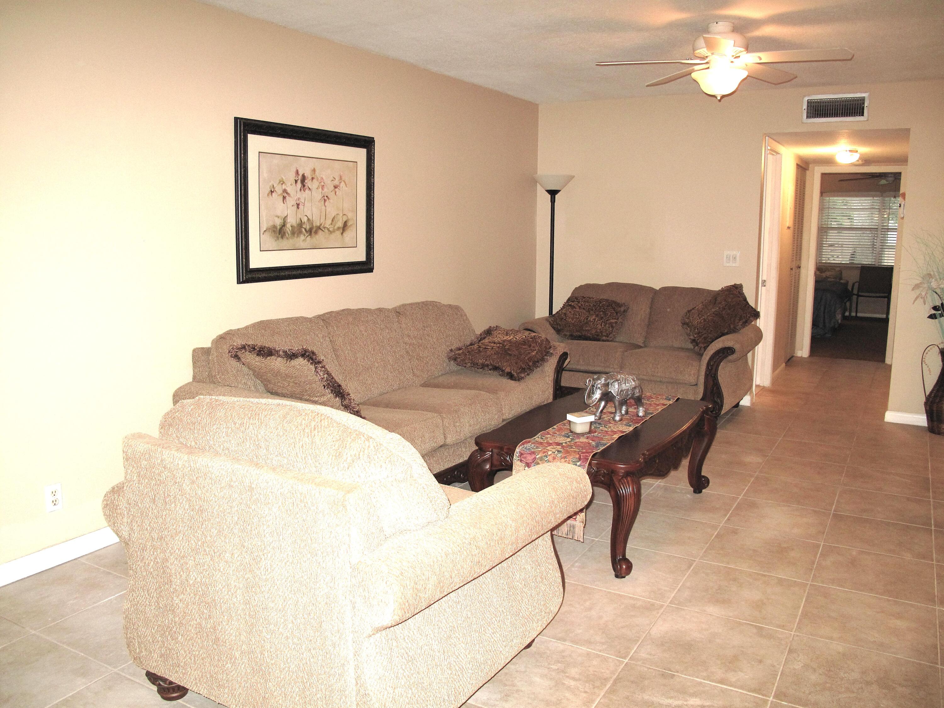 1315 High Point Way Southeast, Unit B Delray Beach, FL 33445 - Photo 11 of 41 a living room with furniture and a chandelier