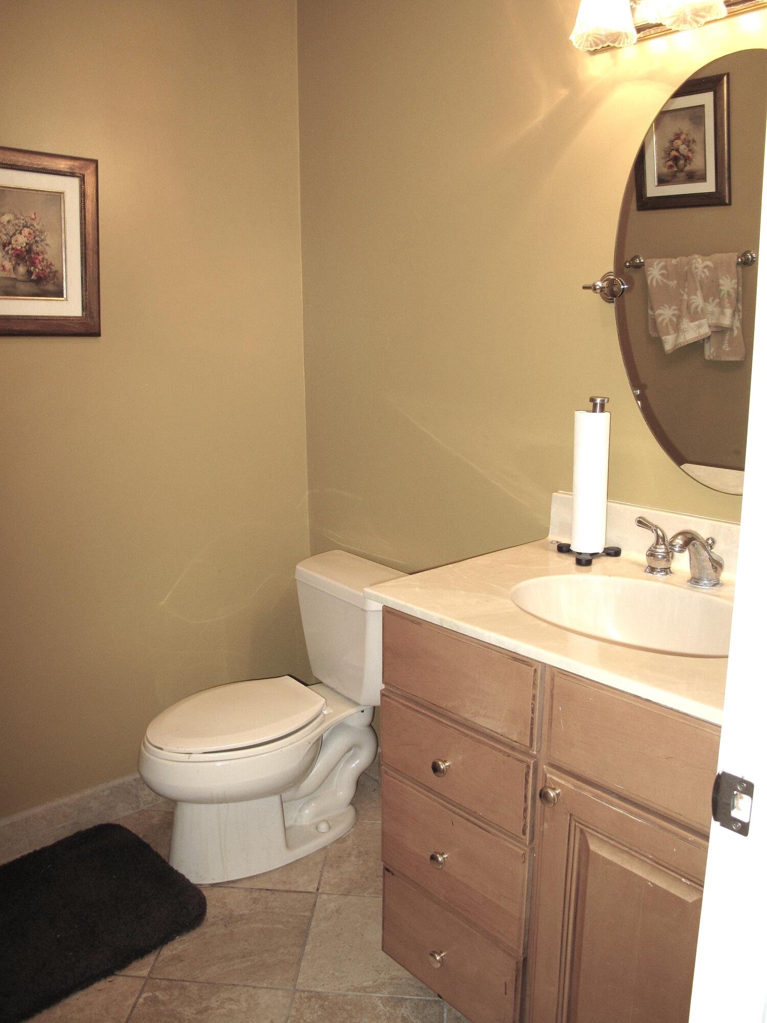 1315 High Point Way Southeast, Unit B Delray Beach, FL 33445 - Photo 15 of 41 a bathroom with a toilet a sink and mirror