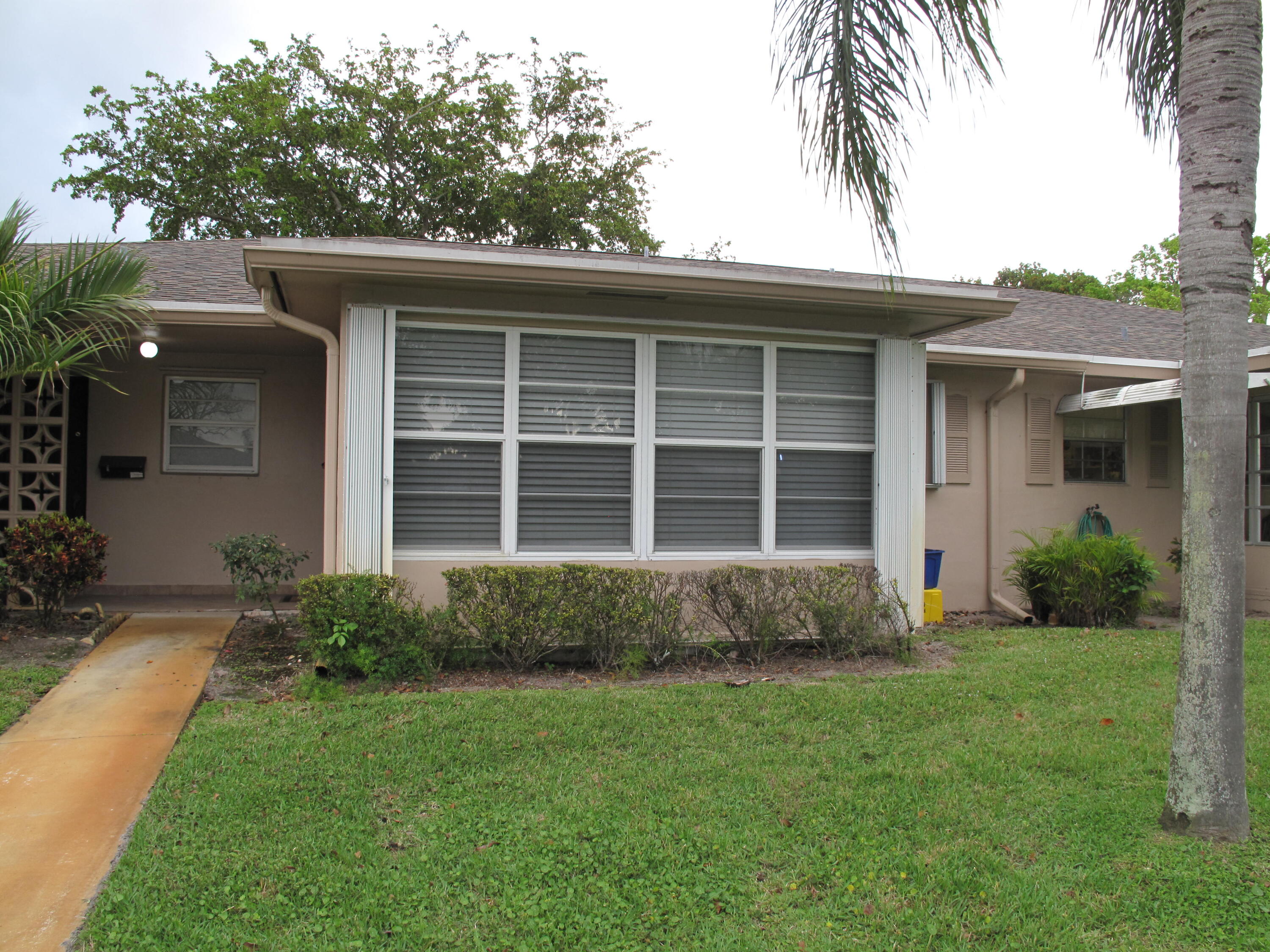 1315 High Point Way Southeast, Unit B Delray Beach, FL 33445 - Photo 2 of 41 a front view of a house with a garden