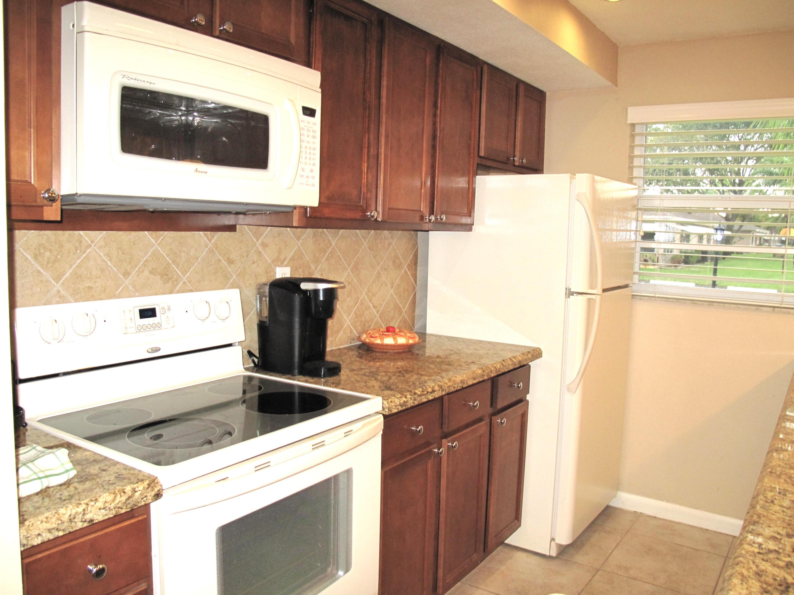 1315 High Point Way Southeast, Unit B Delray Beach, FL 33445 - Photo 6 of 41 a kitchen with a stove and a microwave