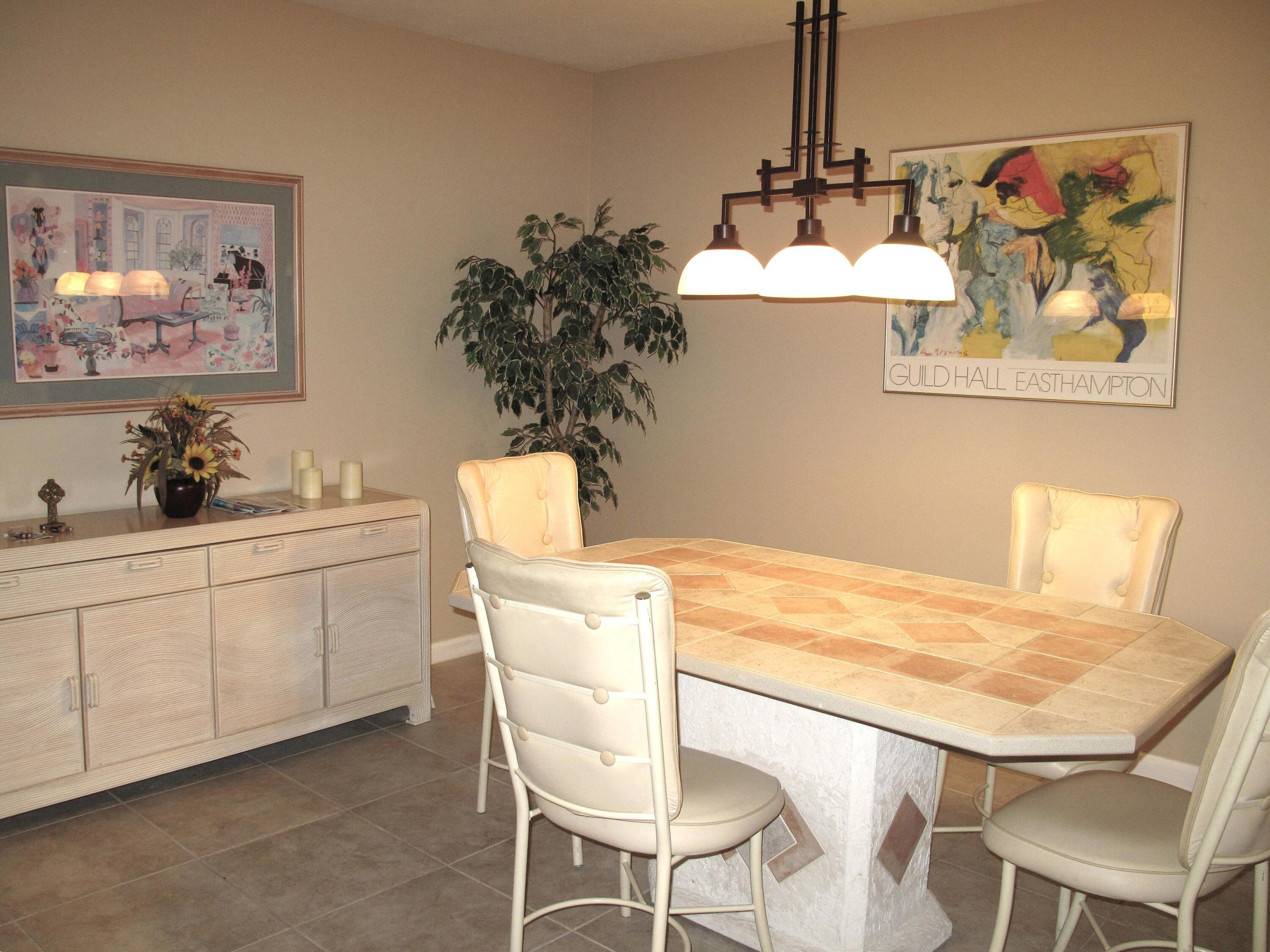 1315 High Point Way Southeast, Unit B Delray Beach, FL 33445 - Photo 8 of 41 a dining room with wooden floor furniture and a chandelier