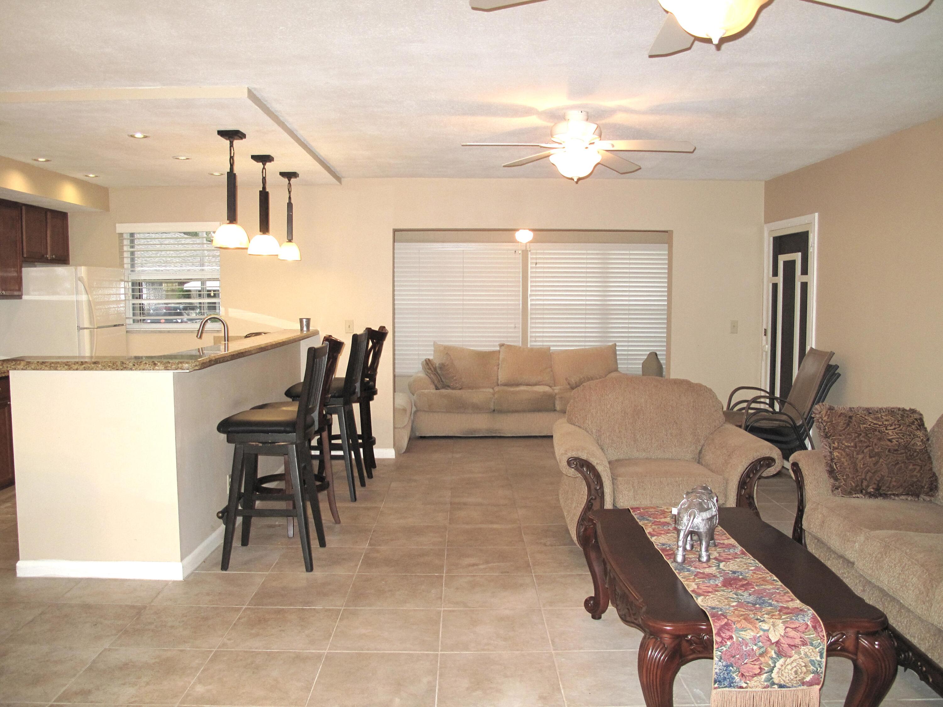 1315 High Point Way Southeast, Unit B Delray Beach, FL 33445 - Photo 9 of 41 a living room with furniture a chandelier and a dining table