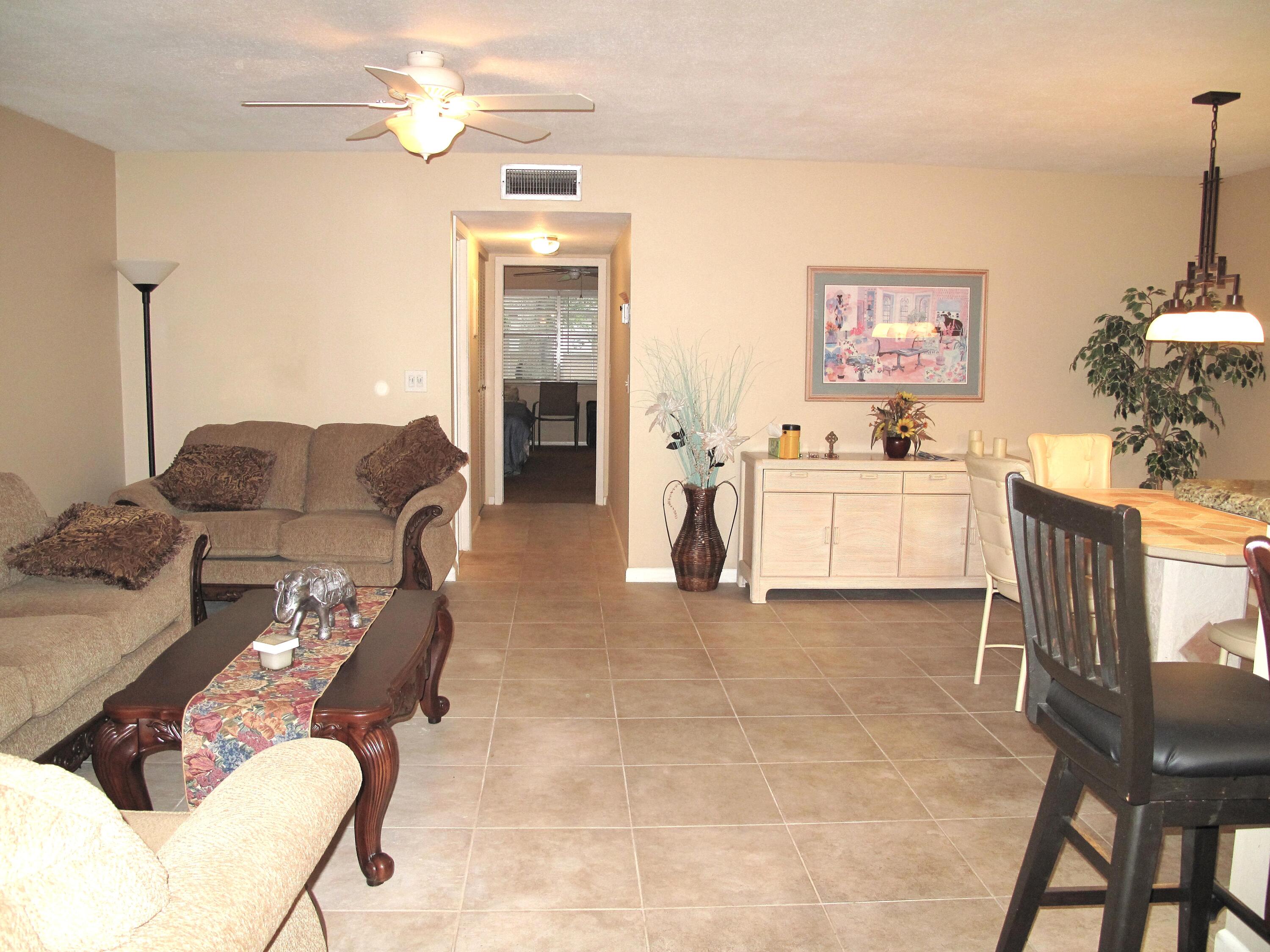 1315 High Point Way Southeast, Unit B Delray Beach, FL 33445 - Photo 10 of 41 a living room with furniture a chandelier and a dining table