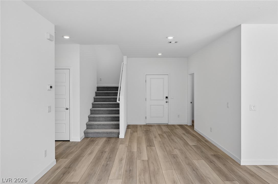 347 Sam Way Mesquite, NV 89027 - Photo 9 of 32 A well-lit entry showcases hardwood-style flooring and a carpeted staircase leading to upper levels.
