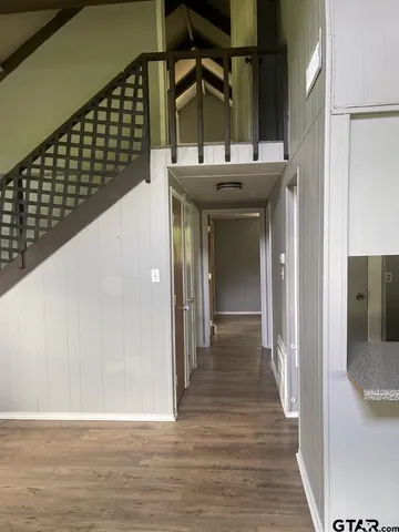 a view of a hallway with wooden floor and staircase