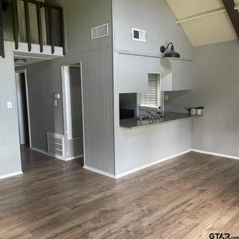 a view of a kitchen with wooden floor and cabinets