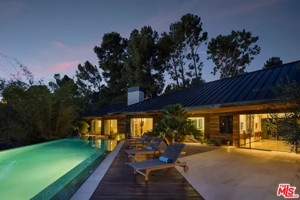 a view of a patio with table and chairs potted plants with wooden floor and plants