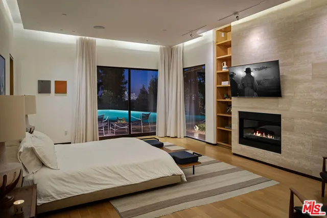 a bedroom with a bed wooden floor and window