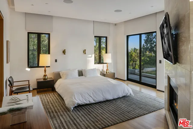 a bedroom with furniture and large windows