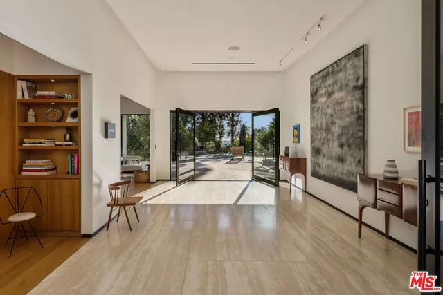 a living room with furniture floor to ceiling window and wooden floor