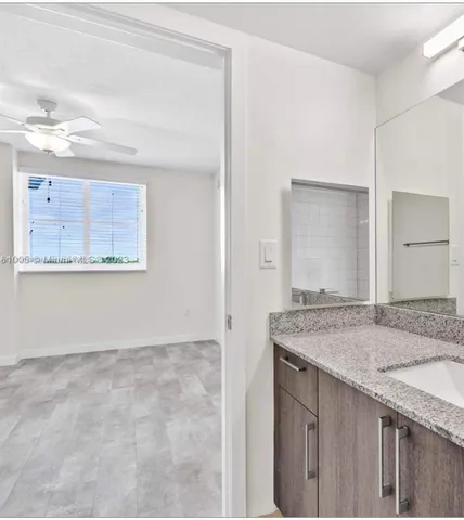 a bathroom with a granite countertop sink and a mirror