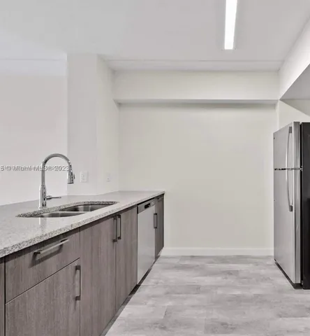 a kitchen with a sink and a refrigerator