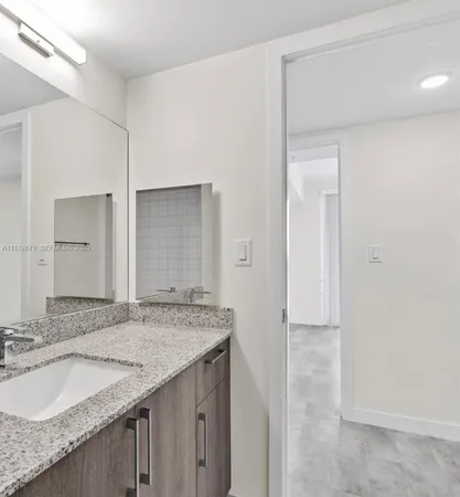 a bathroom with a granite countertop sink and a mirror
