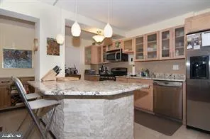 a kitchen with stainless steel appliances granite countertop a stove microwave and refrigerator