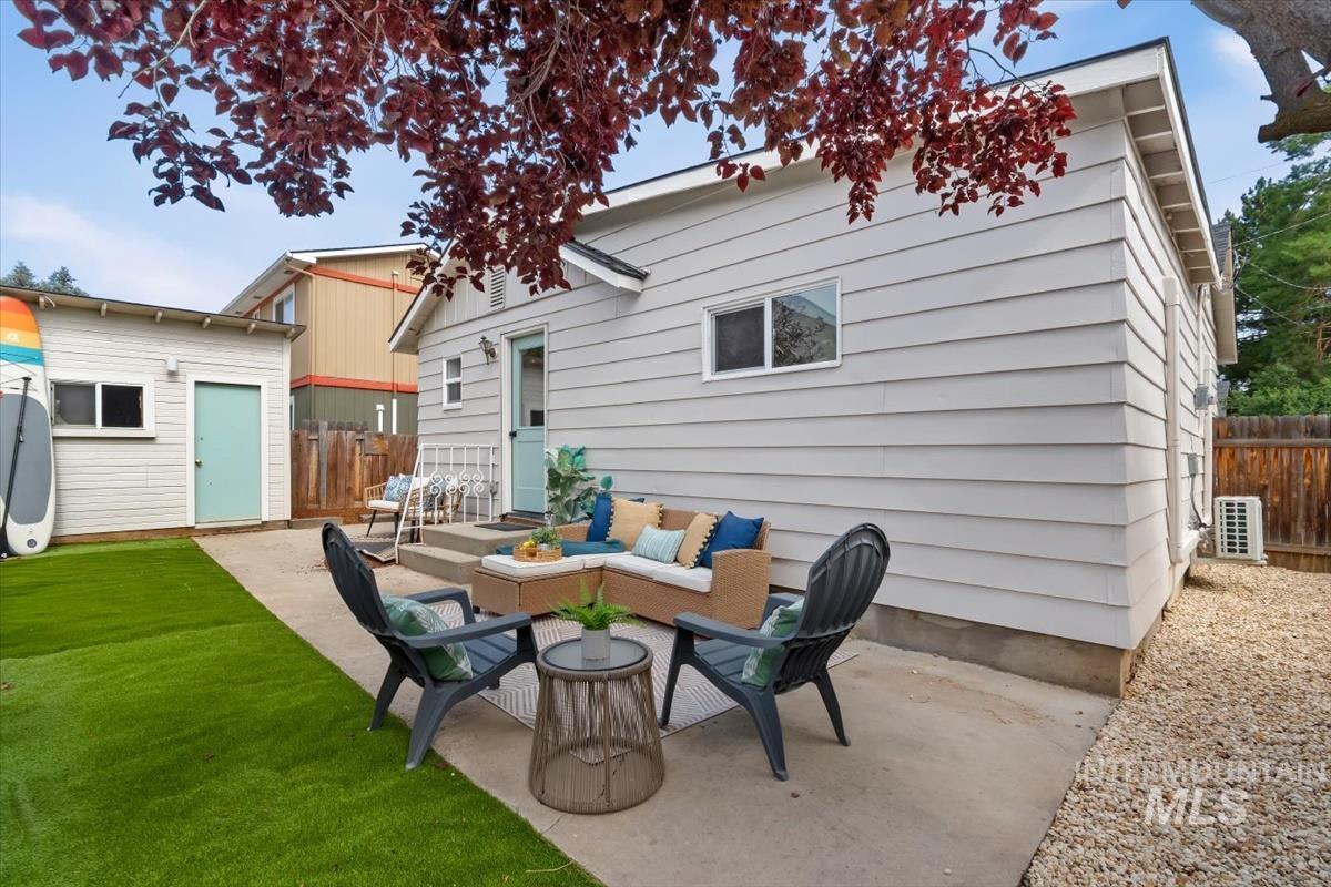 3005 West Hester Street Boise, ID 83702 - Photo 27 of 32 Rear exterior featuring horizontal siding, a concrete patio, a detached storage shed, a manicured artificial turf lawn, and gravel landscaping