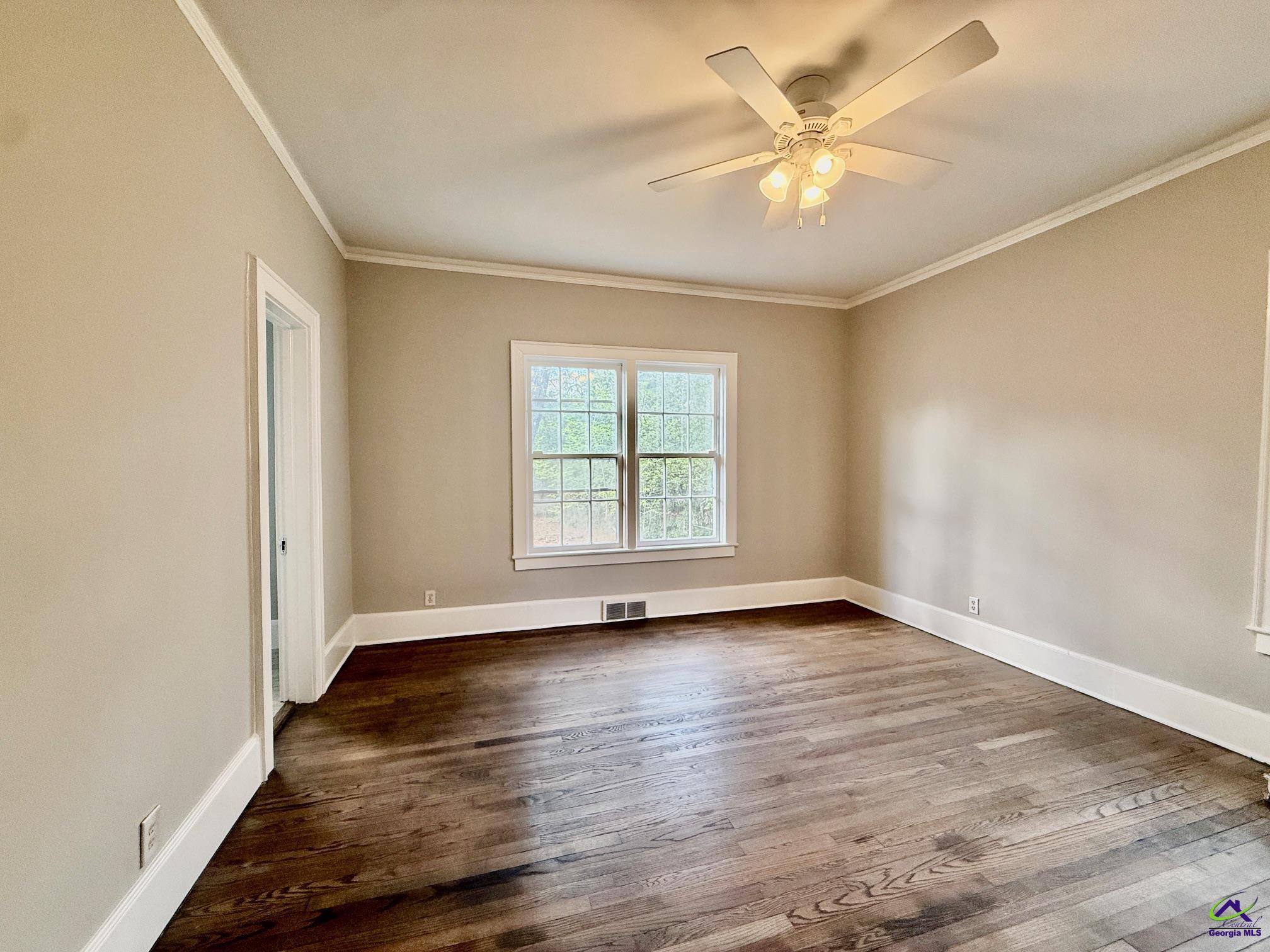 515 Engram Street Montezuma, GA 31063 - Photo 15 of 35 an empty room with wooden floor and windows