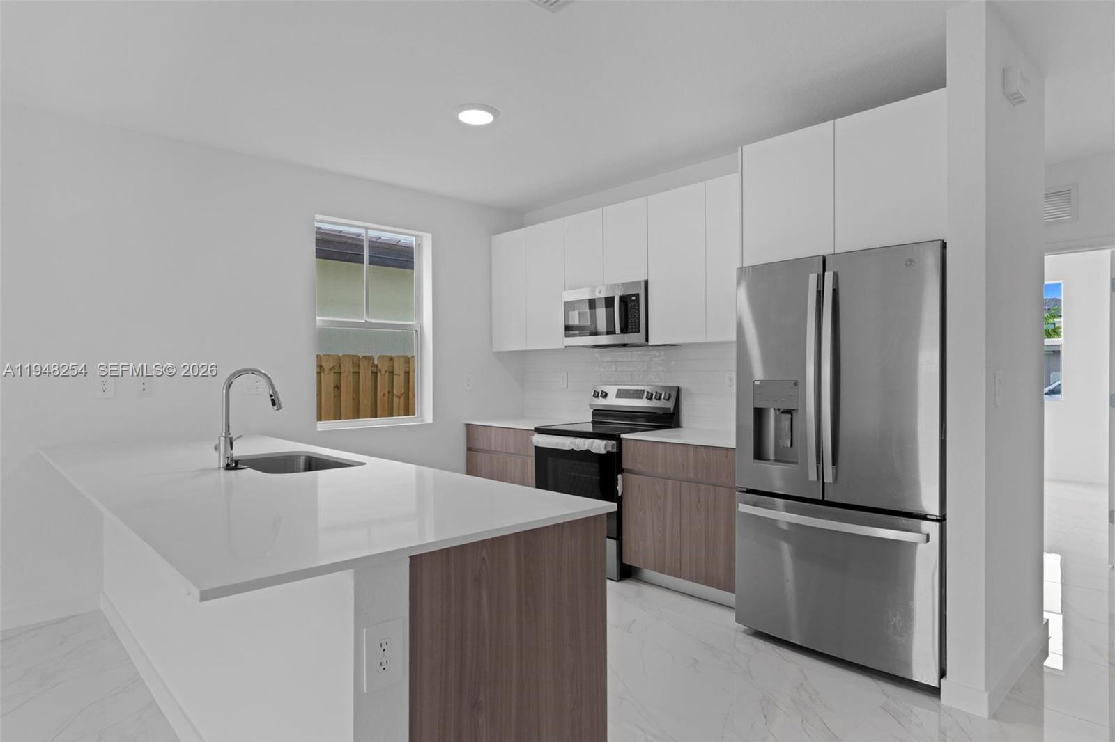 27335 Southwest 133rd Path Homestead, FL 33032 - Photo 16 of 39 a kitchen with kitchen island a refrigerator stove and sink