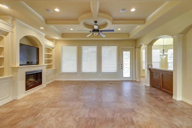 a view of an empty room with a fireplace and a window
