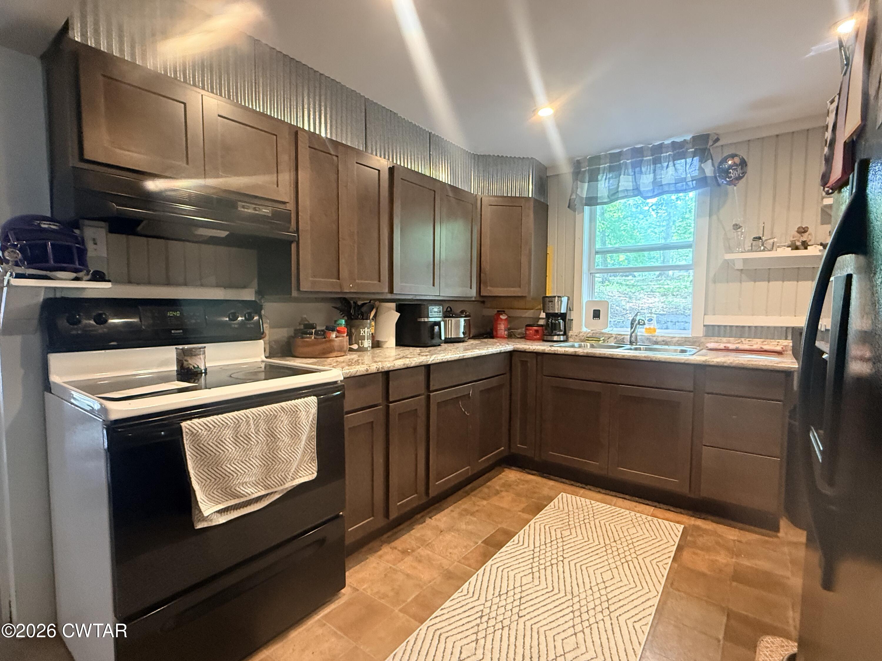 133 Maxine Nelson Road Parsons, TN 38363 - Photo 11 of 19 a kitchen with a sink stove and cabinets