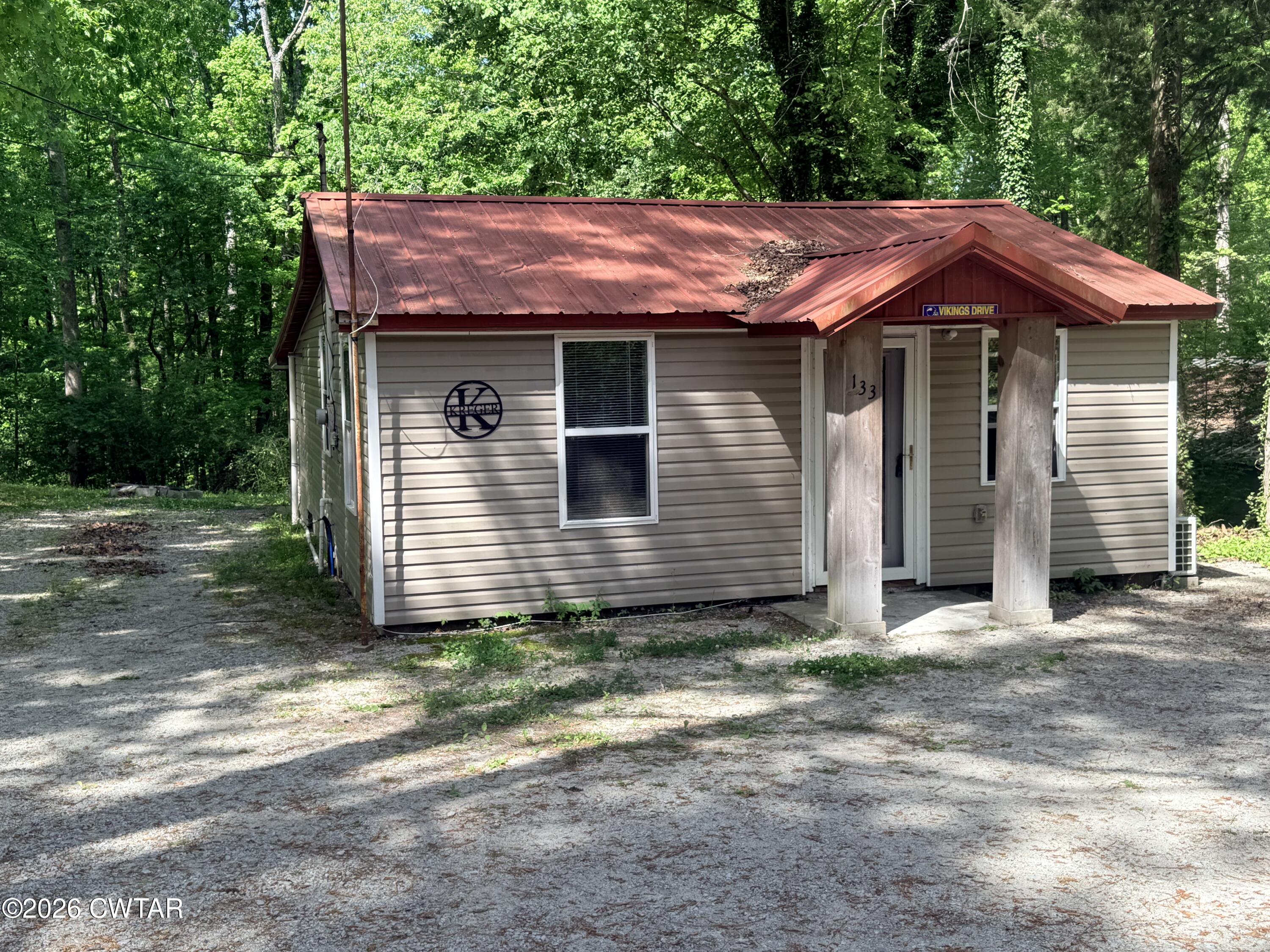 133 Maxine Nelson Road Parsons, TN 38363 - Photo 2 of 19 a wooden house with a small yard and large trees