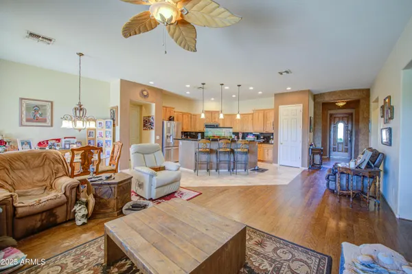 a dining hall with stainless steel appliances kitchen island granite countertop a living room view