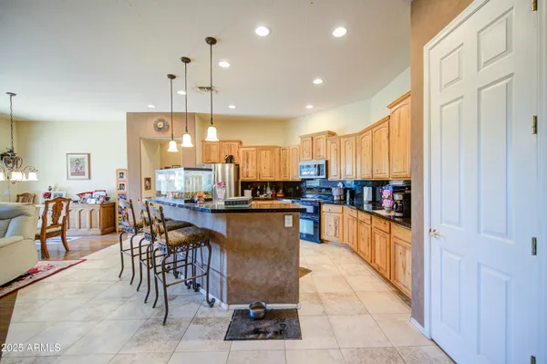a kitchen with stainless steel appliances granite countertop a refrigerator a stove top oven a sink and dishwasher
