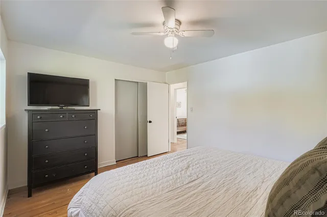 a bedroom with a bed and a flat tv screen on dresser