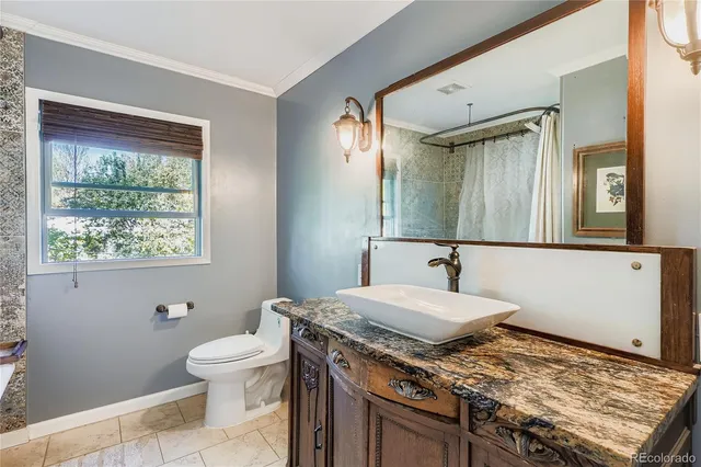 a bathroom with a granite countertop sink toilet and mirror