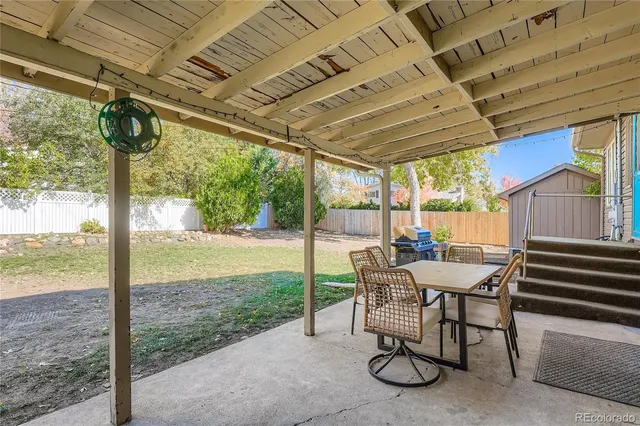 a view of a patio with a table chairs and a backyard