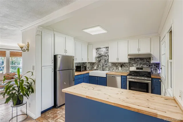 a kitchen with a refrigerator and a stove top oven