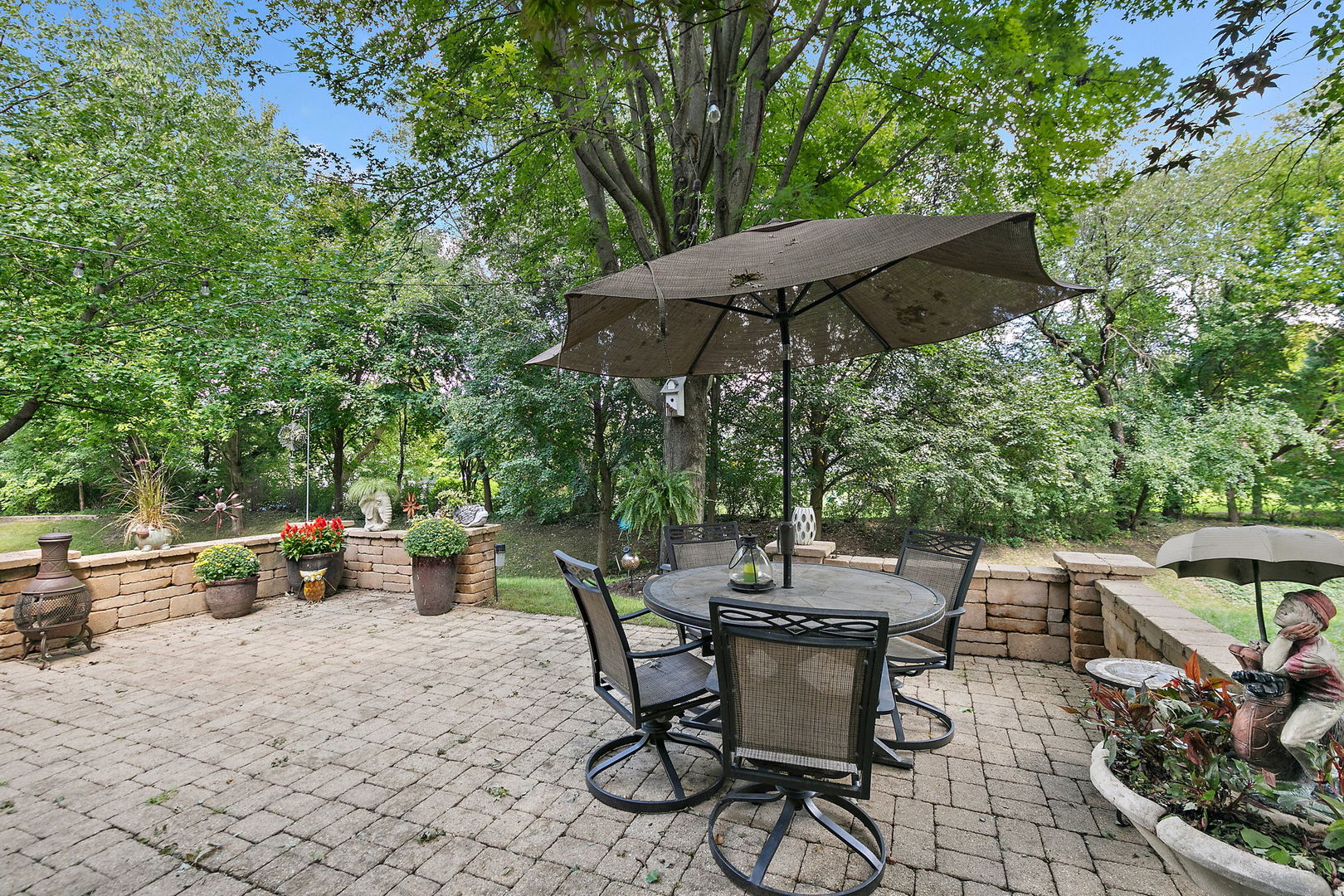 406 Catkins Way Cary, IL 60013 - Photo 31 of 32 a view of patio with table and chairs under an umbrella
