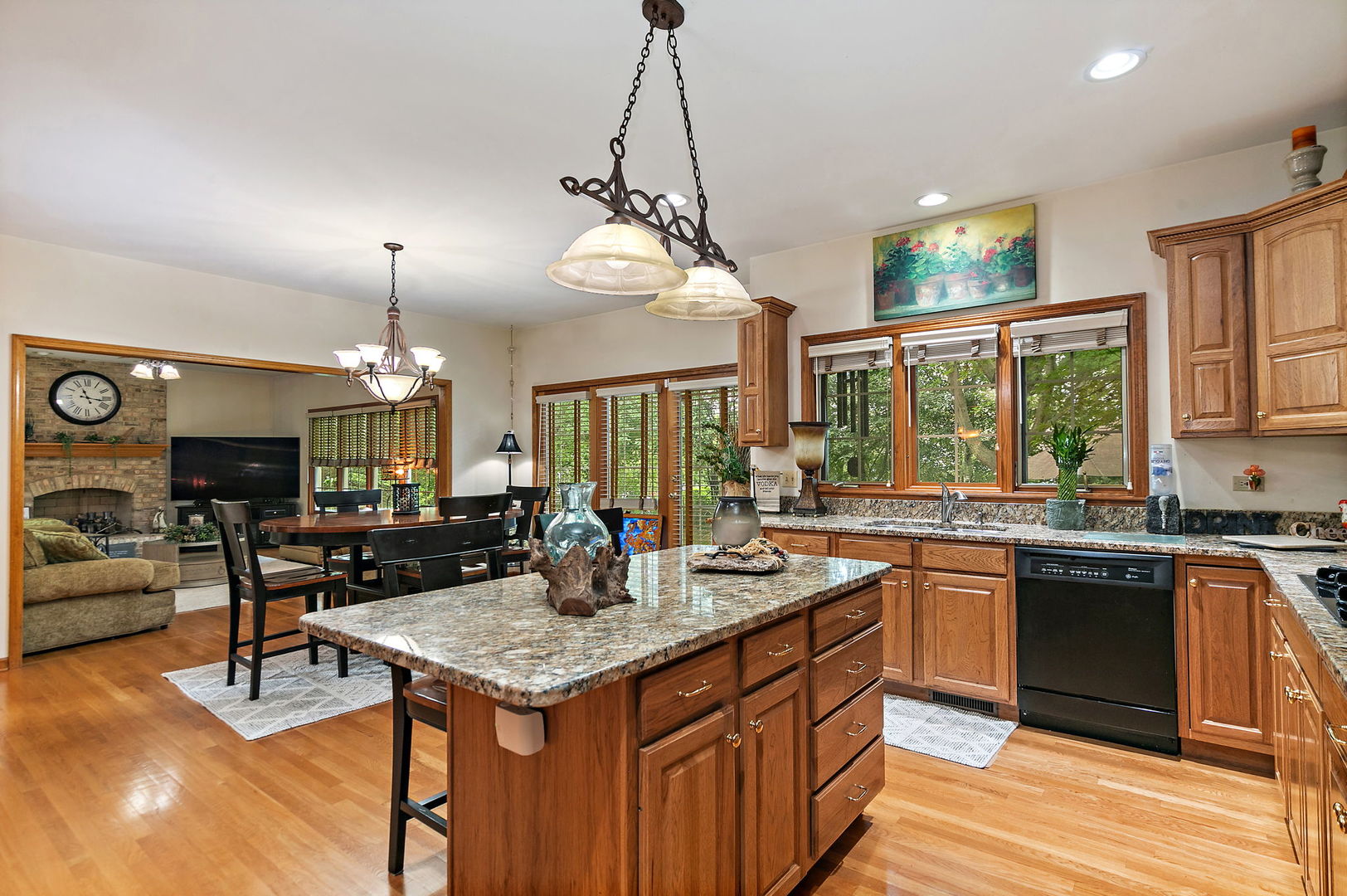 406 Catkins Way Cary, IL 60013 - Photo 10 of 32 a kitchen with a stove a sink dishwasher a dining table and chairs with wooden floor