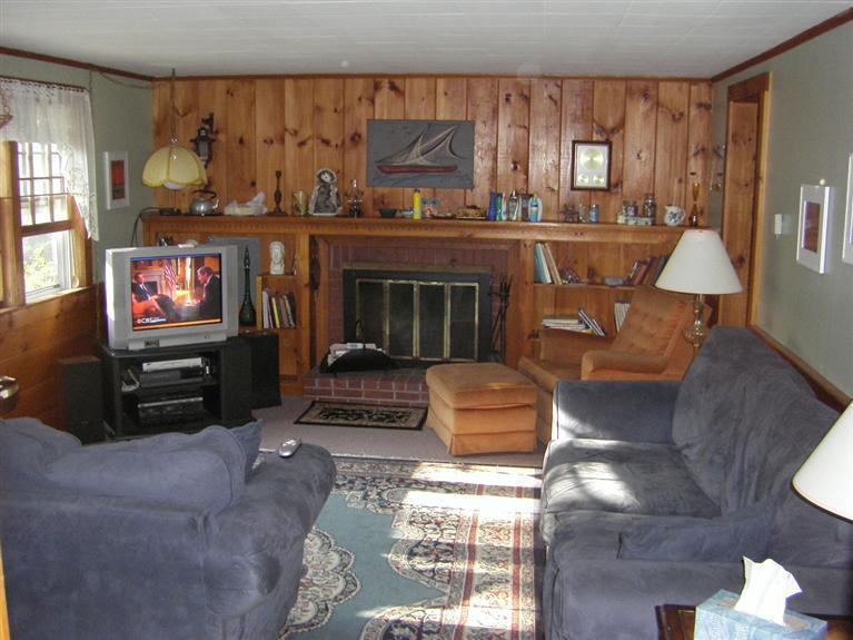 55 Captain Chase Road Dennis Port, MA 02639 - Photo 2 of 18 a living room with furniture a flat screen tv and a fireplace