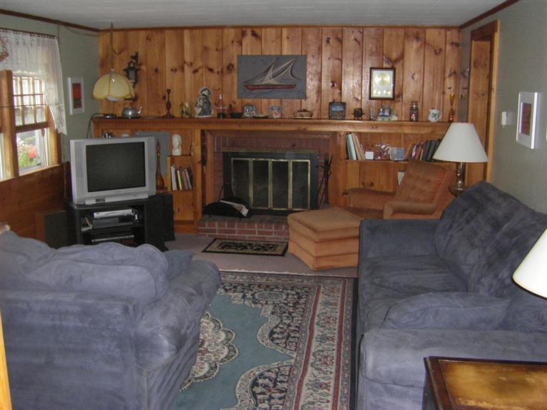 55 Captain Chase Road Dennis Port, MA 02639 - Photo 6 of 18 a living room with furniture a flat screen tv and a fireplace