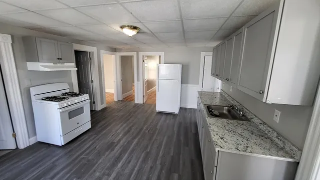 a kitchen with a refrigerator and white cabinets