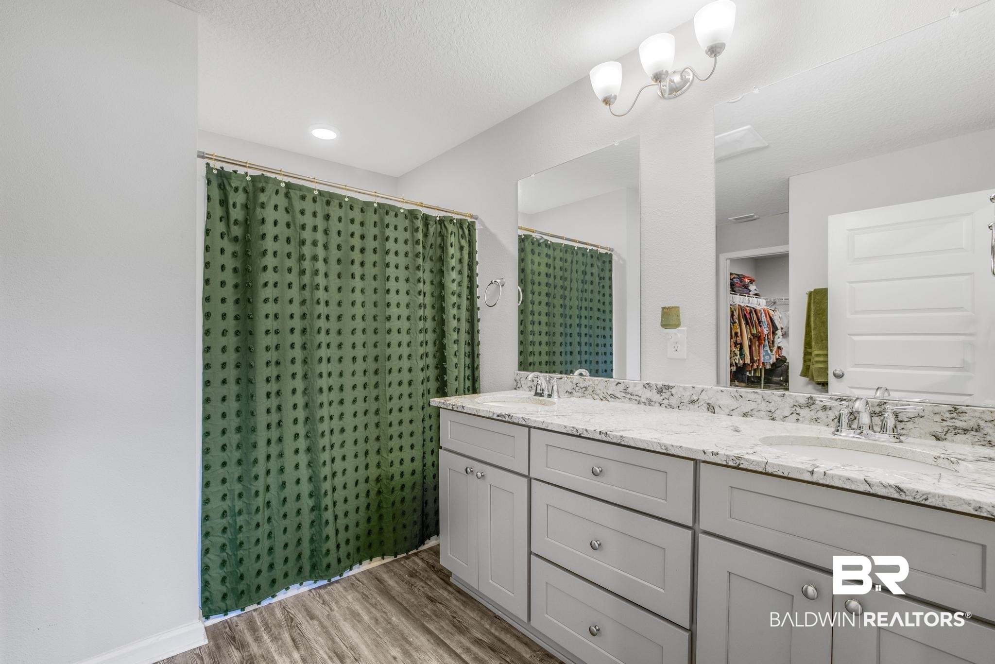 10738 Ridgeview Drive Mobile, AL 36608 - Photo 25 of 48 Bathroom with a shower stall, a spacious closet, double vanity, light wood-style flooring, and a textured ceiling