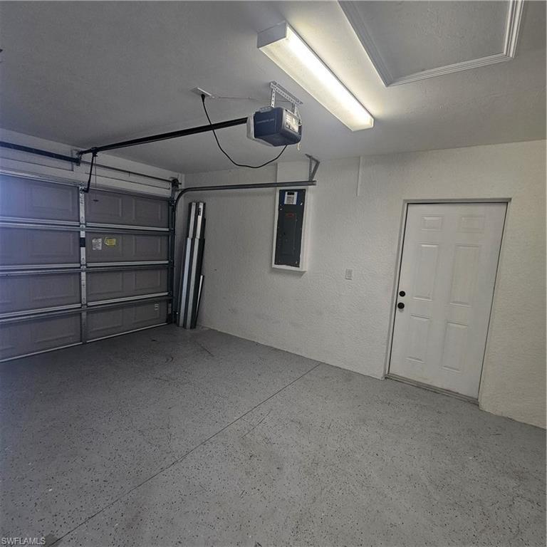 4722 29th Street Southwest Lehigh Acres, FL 33973 - Photo 11 of 12 Garage with electric panel and a garage door opener