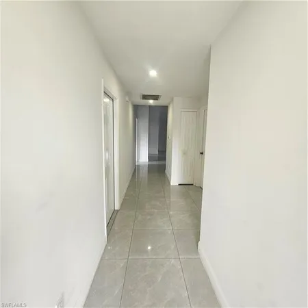 a view of hallway with a rug and a window
