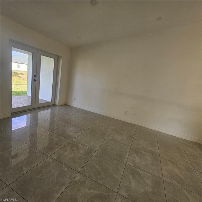 4722 29th Street Southwest Lehigh Acres, FL 33973 - Photo 4 of 12 Tiled spare room with baseboards and french doors
