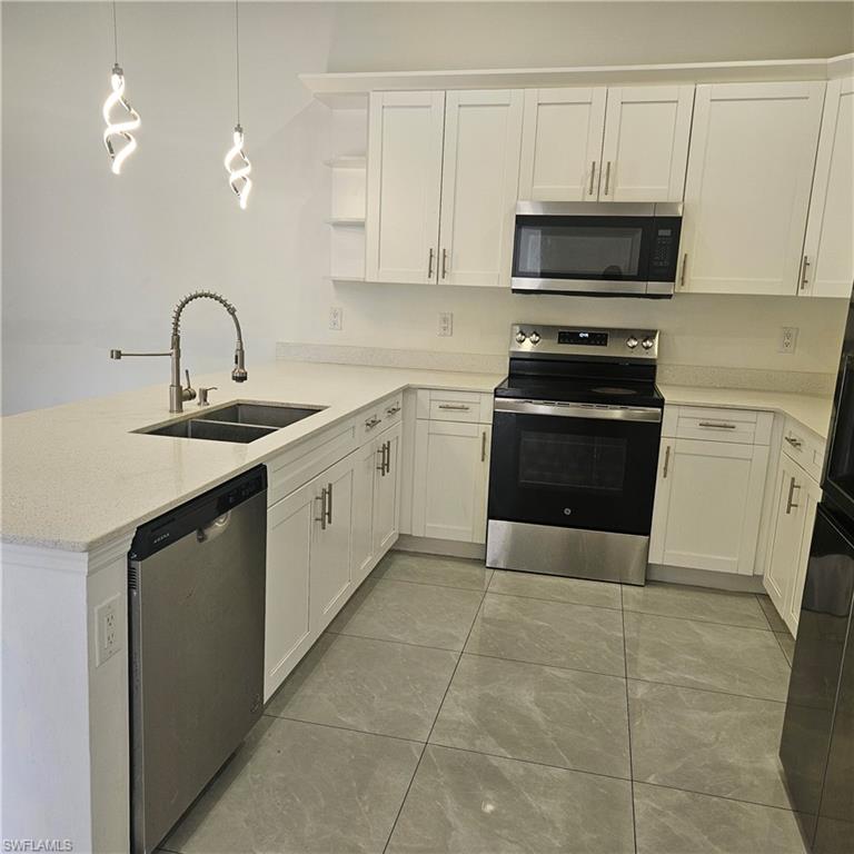 4722 29th Street Southwest Lehigh Acres, FL 33973 - Photo 6 of 12 Kitchen featuring stainless steel appliances, a peninsula, white cabinets, hanging light fixtures, and open shelves