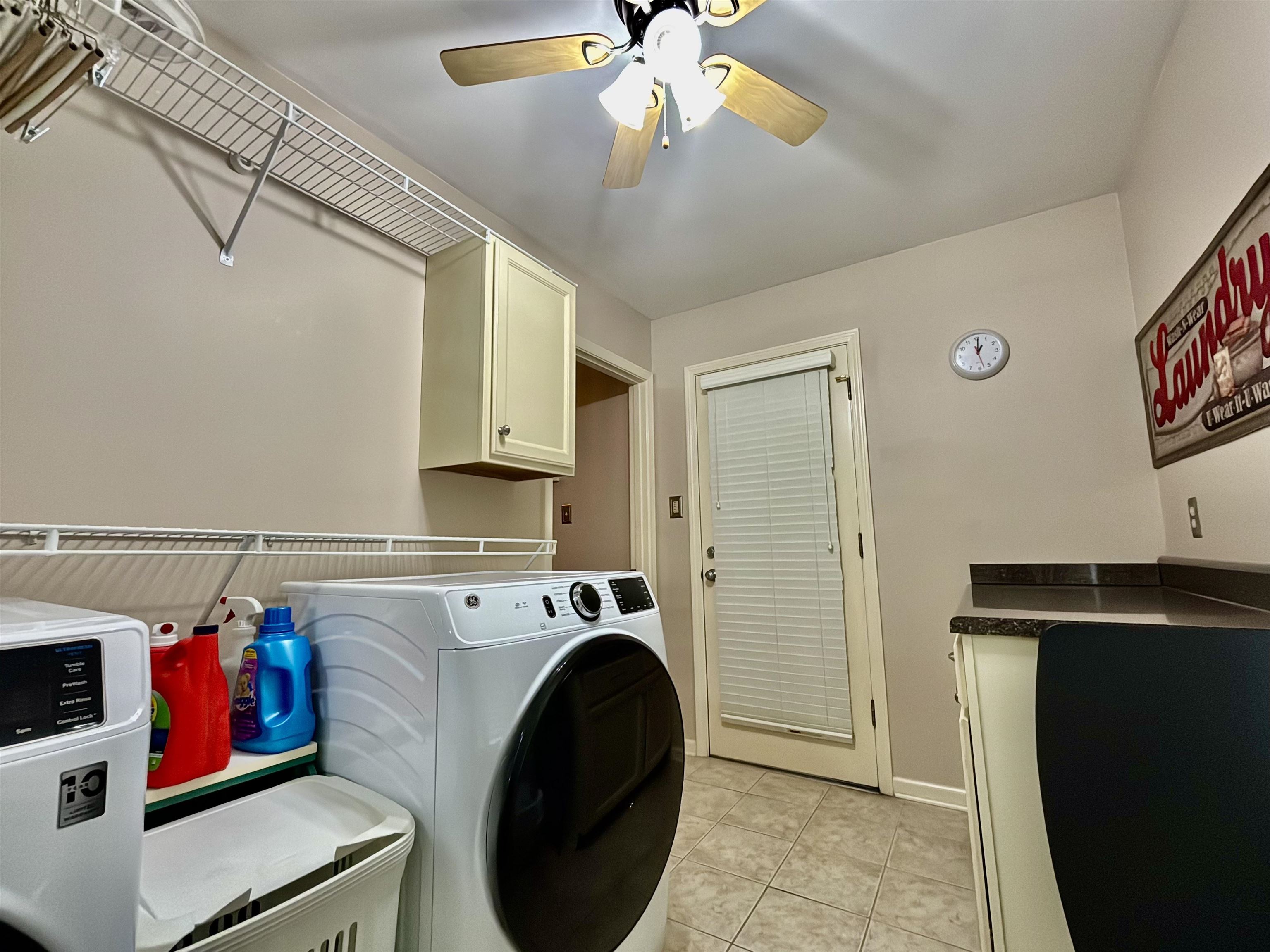 4267 Old Forest Road Memphis, TN 38125 - Photo 9 of 24 Clothes washing area featuring washing machine and clothes dryer, ceiling fan, light tile patterned floors, and cabinets