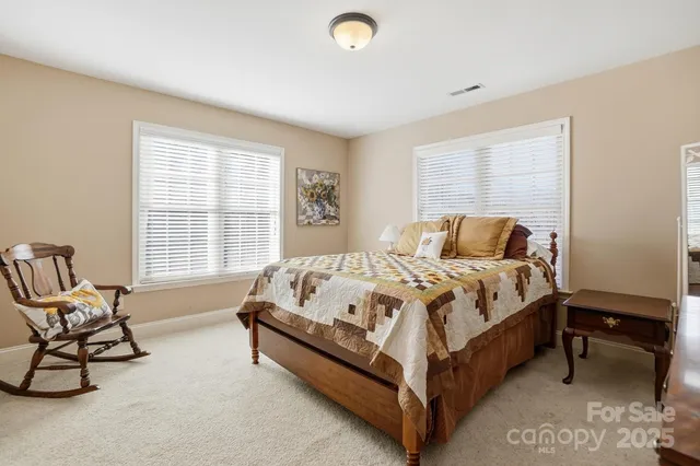 a bed sitting in a bedroom next to a window