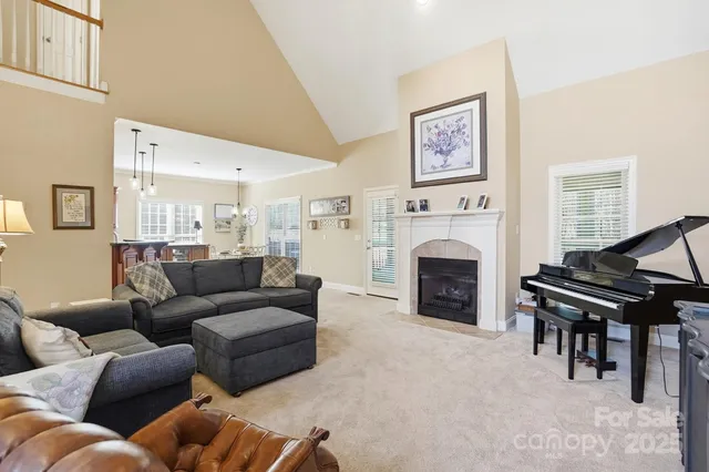 a living room with furniture a fireplace and a large window