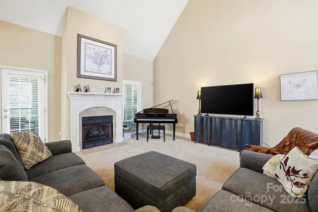 a living room with furniture a flat screen tv and a fireplace