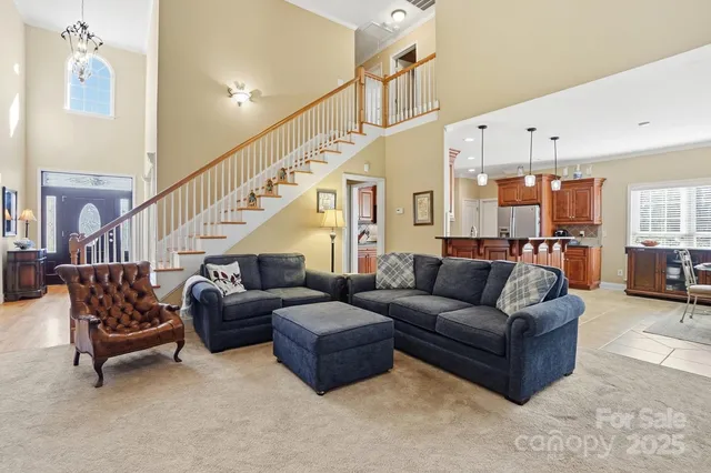 a living room with furniture kitchen view and a chandelier