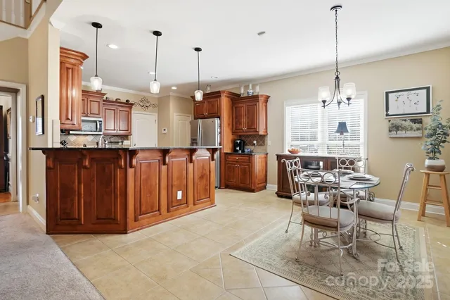 a view of a kitchen with kitchen island granite countertop wooden cabinets and stainless steel appliances