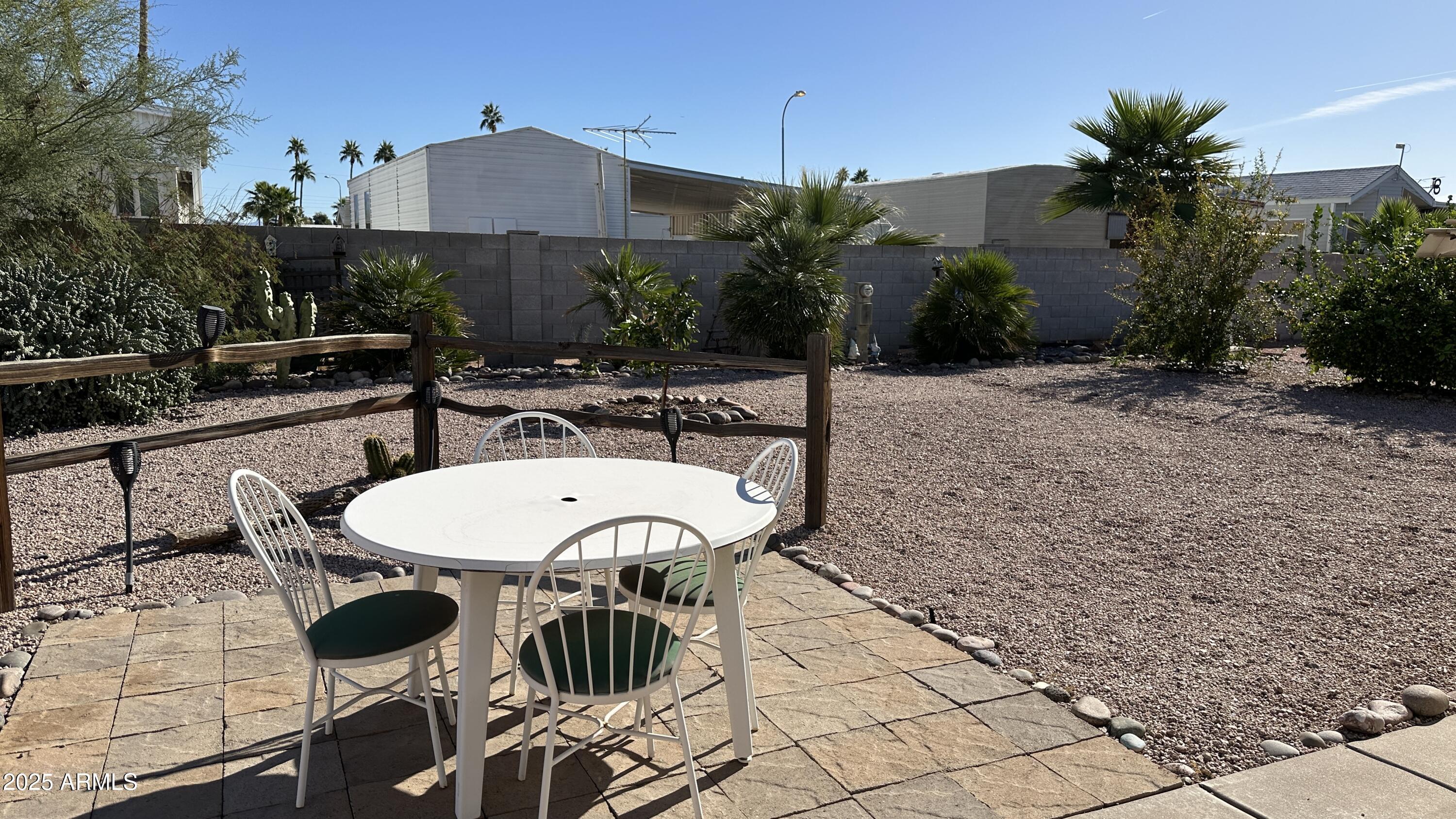 834 South Meridian Road, Unit 105 Apache Junction, AZ 85120 - Photo 37 of 48 a view of a patio with table and chairs potted plants with wooden floor