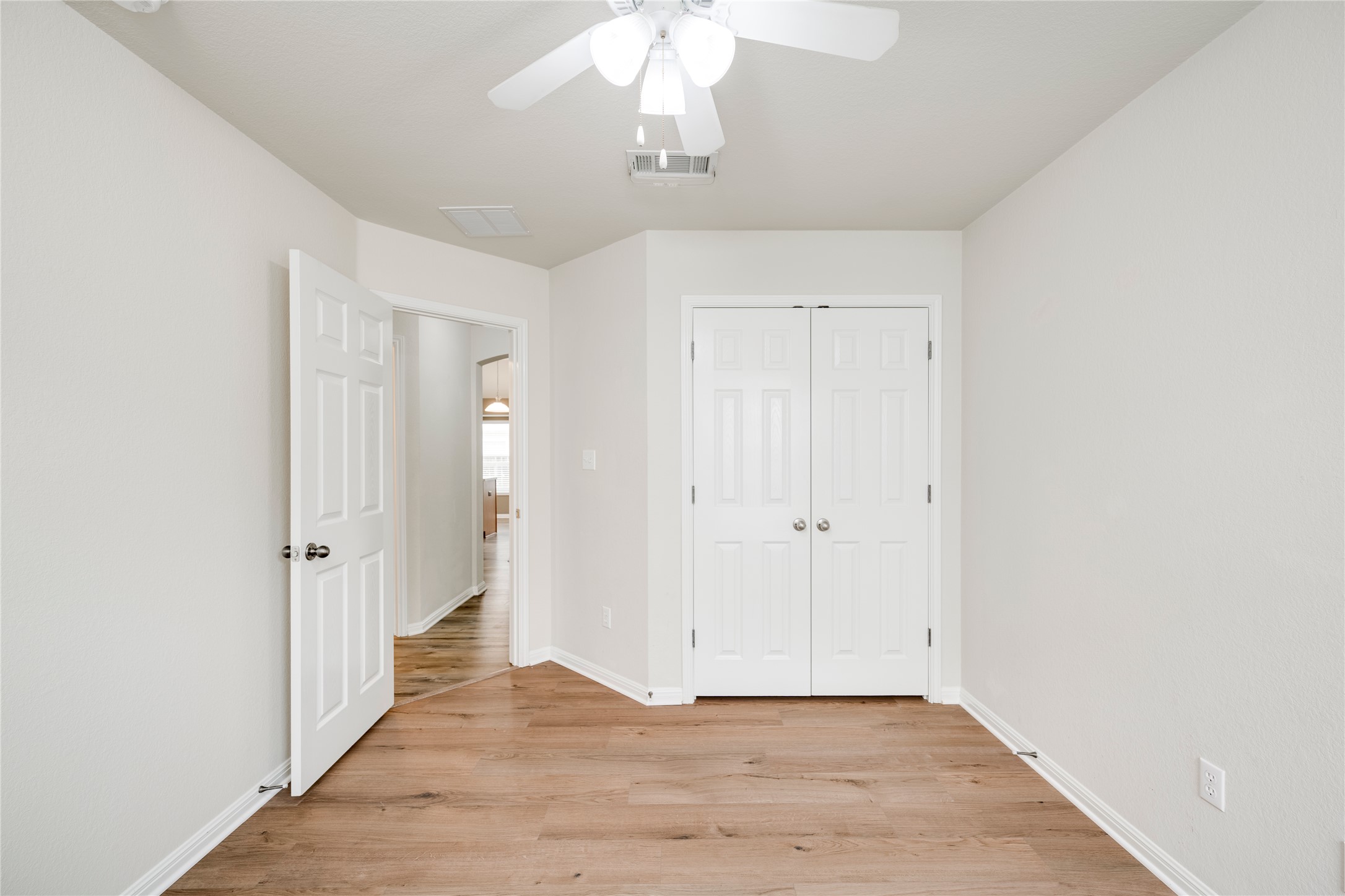 1813 Nelson Ranch Loop Cedar Park, TX 78613 - Photo 26 of 39 A well-lit bedroom with durable hardwood flooring and a functional ceiling fan, offering a comfortable personal space.